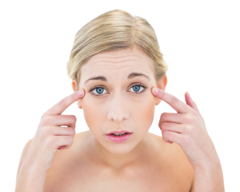 Worried blond woman checking her face for wrinkles