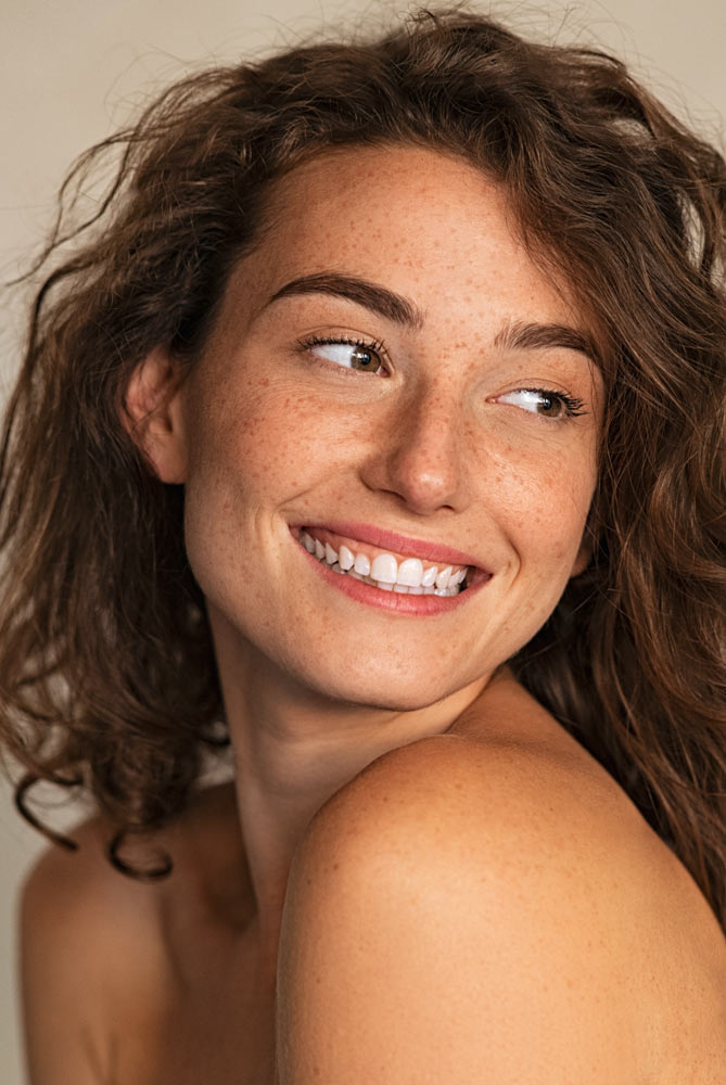 Smiling beauty woman with freckles looking away